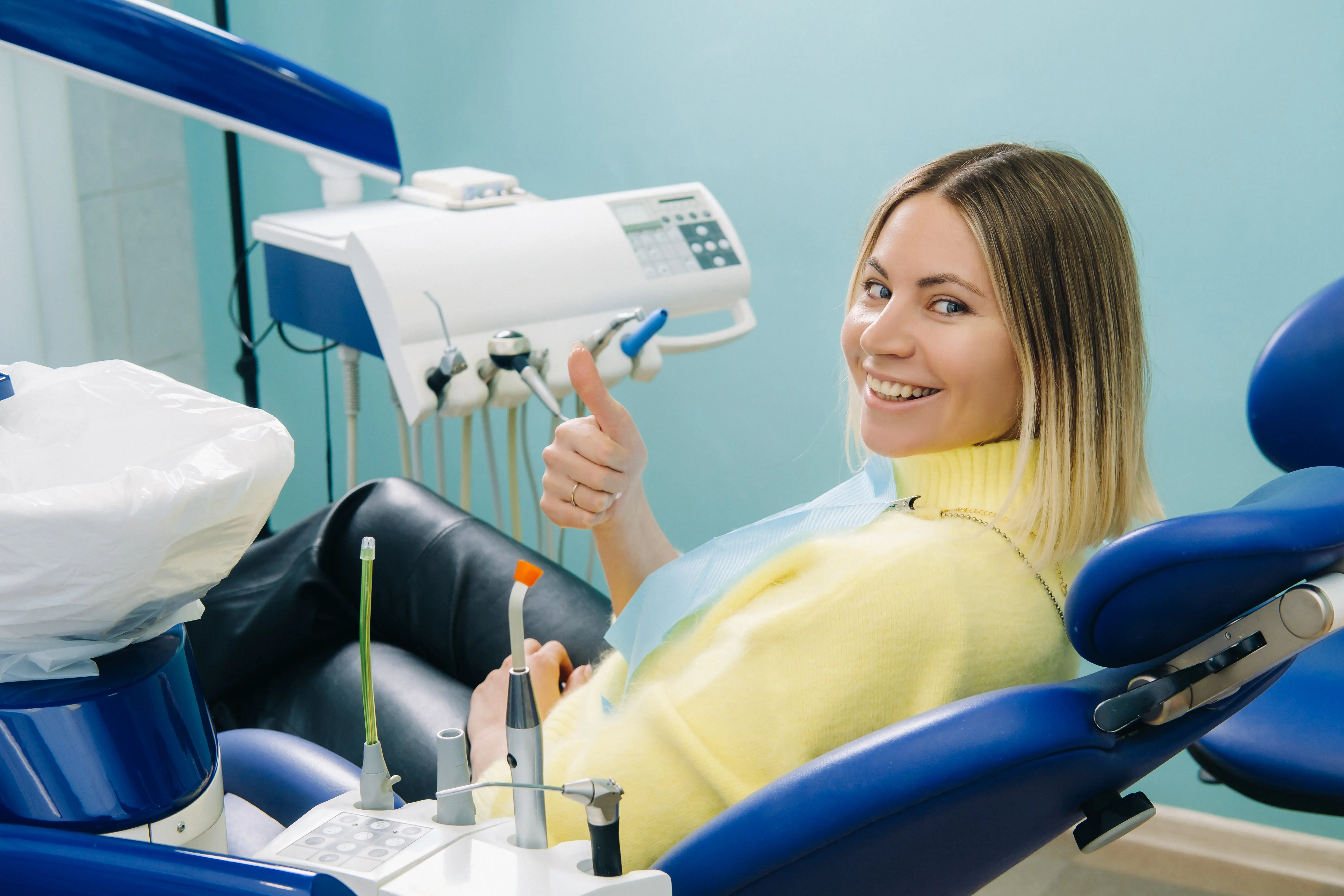 Beautiful Girl Patient Shows The Class With Her Hand While Sitting In The Dentist's Chair